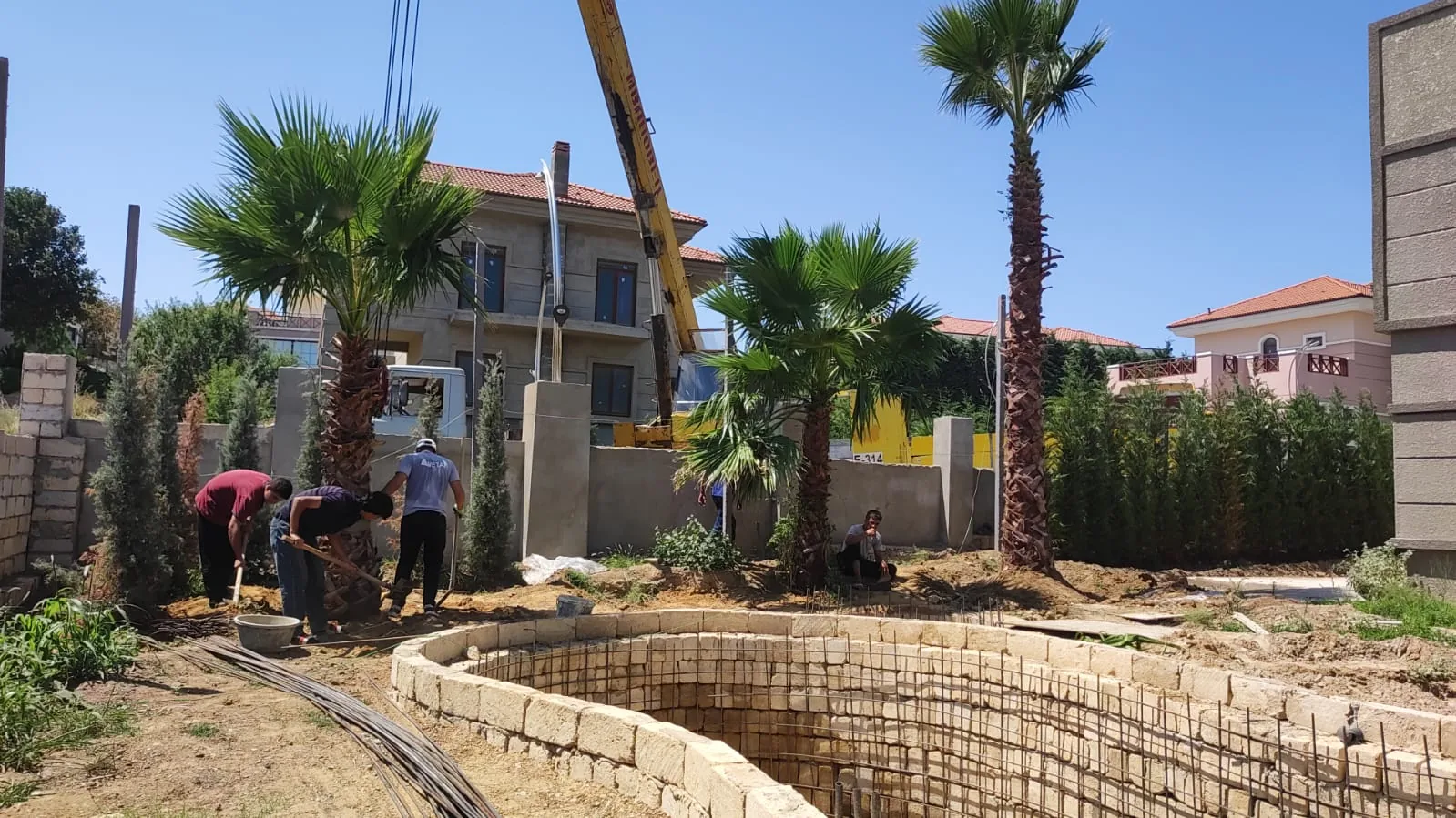 Həyətyanı sahədə işçilər və tikinti işlərinin gedişi